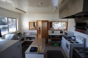 eine kleine Küche mit Herd und Spüle in der Unterkunft Pukenui Lodge in National Park