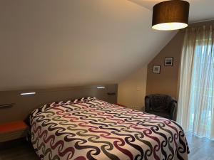 a bedroom with a large bed and a window at Chambres Saint-Jamaises in Saint-James