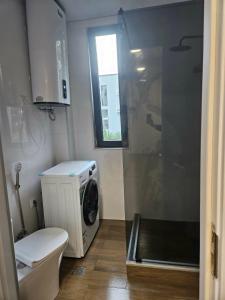 a bathroom with a toilet and a washing machine at Sun Estate Ureki in Ureki