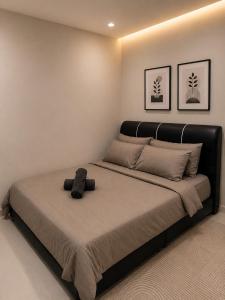 a large bed with a black headboard in a bedroom at Dmana Homestay Arau Perlis in Arau