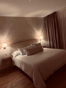 a bedroom with a large white bed with two lamps at Kanaloa Lodge in Galizano