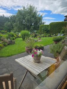 a wooden picnic table with flowers on a patio at Ferienwohnung mit kleinem Garten in Nettersheim