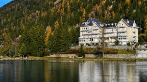 a large building on the shore of a body of water at Petit Canada - Studio à louer in Champex