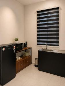a kitchen with a black refrigerator and a sink at Dmana Homestay Arau Perlis in Arau