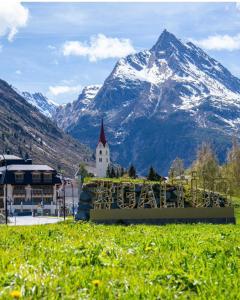 a church with a mountain in the background at Piz Arina Inklusiv Premium - Card in Galtür