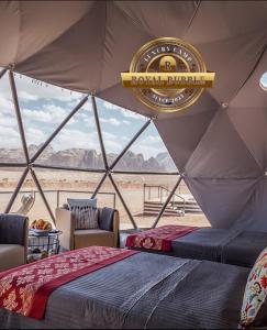 ein Zelt mit Betten und einem Schild mit der Aufschrift „Königliche Burka“ in der Unterkunft ROYAL BUBBLE lUXURY CAMP in Wadi Rum