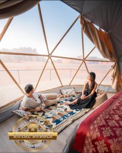 Eine Gruppe von Menschen sitzt auf dem Boden einer Jurte. in der Unterkunft ROYAL BUBBLE lUXURY CAMP in Wadi Rum