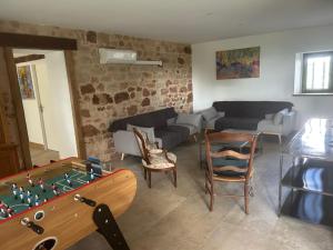 a living room with a couch and a pool table at Gîte Les Jacquets in Hautefort