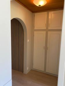 an empty room with white cabinets and a radiator at Appartment in Jørpeland
