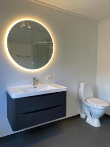 a bathroom with a sink and a toilet and a mirror at Appartment in Jørpeland