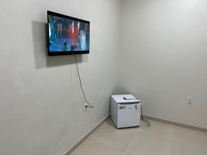 a flat screen tv hanging on a white wall at Dormitório in Barreirinhas