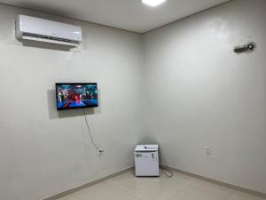 a white room with a tv on a wall at Dormitório in Barreirinhas