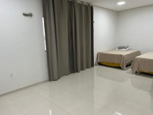 a hospital room with two beds and curtains at Dormitório in Barreirinhas