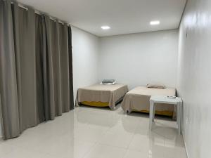 a hospital room with two beds and a table at Dormitório in Barreirinhas