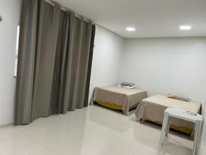 a hospital room with two beds and curtains at Dormitório in Barreirinhas
