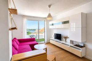 a living room with a pink couch and a tv at Brisa de Usil in Mogro