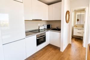 a kitchen with white cabinets and a stove top oven at Brisa de Usil in Mogro