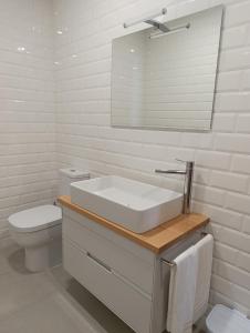 a white bathroom with a sink and a toilet at Casa do Patrão Serradalto in Manteigas +10 photos