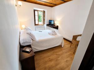 a small bedroom with a bed and a window at Airtegal Casa do Puntal in Valdoviño