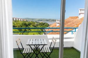a table and chairs on a balcony with a view at Brisa de Usil in Mogro