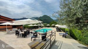a patio with tables and chairs and a swimming pool at Villa Rosaria B&B in Morano Calabro