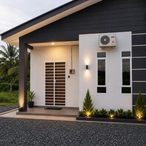a white house with a fan in front of it at Dmana Homestay Arau Perlis in Arau