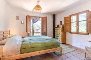 a bedroom with a bed and a dresser and a window at Casa Lola - off grid vakantiehuisje - Puerto Mika in Torviscón