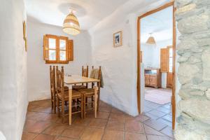 a kitchen and dining room with a table and chairs at Casa Lola - off grid vakantiehuisje - Puerto Mika in Torviscón