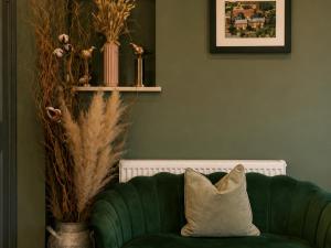 a green couch with a pillow in a living room at Stratford Limes Hotel in Stratford-upon-Avon