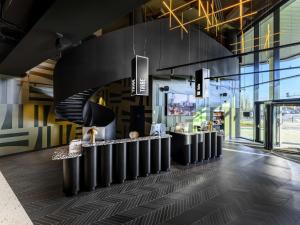 a lobby of a building with a row ofools at ibis Budapest Stadium in Budapest