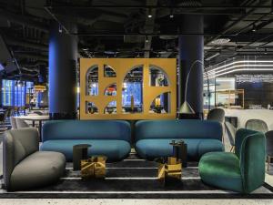 a room with a couch and chairs in a room at ibis Budapest Stadium in Budapest