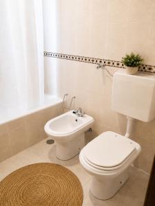 a white toilet and a sink in a bathroom at 3B flat in Portimão +10 photos
