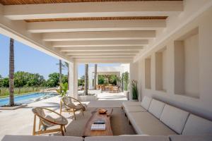 a living room with a couch and chairs and a pool at Tenuta Legaro in Cozzana