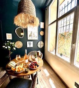 a room with a table with fruits and wine glasses at Escale Singulière - Balnéo, patio et confort 4 étoiles in Sète