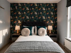 a bedroom with a large bed with a floral wallpaper at Stratford Limes Hotel in Stratford-upon-Avon +24 photos