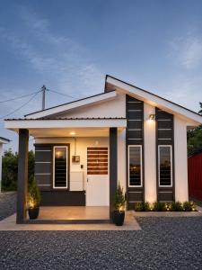 a house with black and white shutters at Dmana Homestay Arau Perlis Tiny House in Arau