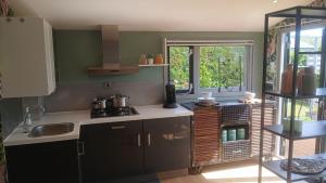 a kitchen with a stove and a sink and a window at Sunny Side at the Sea in Hoek van Holland
