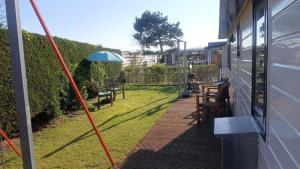 a view of a yard with chairs and an umbrella at Sunny Side at the Sea in Hoek van Holland