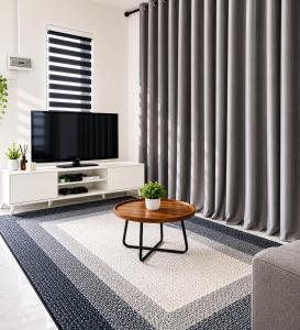 a living room with a tv and a coffee table at Dmana Homestay Arau Perlis Tiny House in Arau +2 photos