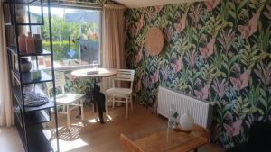 a living room with a table and chairs and a wall at Sunny Side at the Sea in Hoek van Holland +10 photos