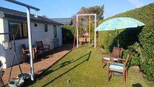 a patio with a table and chairs and an umbrella at Sunny Side at the Sea in Hoek van Holland