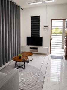 a living room with a tv and a coffee table at Dmana Homestay Arau Perlis Tiny House in Arau