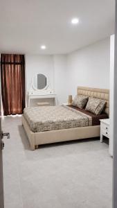 a bedroom with a large bed and a mirror at Appart Ilyani in El Kseur
