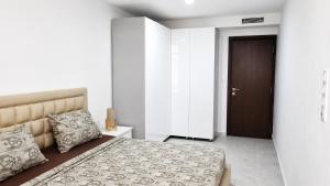 a bedroom with a large bed and a brown door at Appart Ilyani in El Kseur