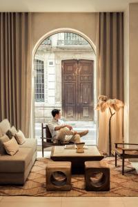 a man sitting on a couch in a living room at Hotel Well and Come Málaga in Málaga +57 photos