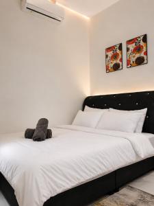 a bedroom with a bed with a stuffed animal on it at Dmana Homestay Arau Perlis Tiny House in Arau