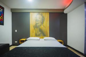 a bedroom with a bed and a colorful wall at Hotel Kalifornia in Bello