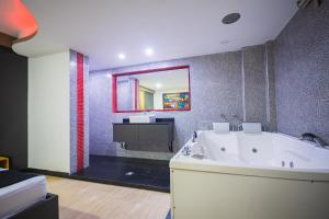 a large bathroom with a tub and a mirror at Hotel Kalifornia in Bello