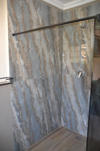 a shower with a glass door in a bathroom at Sea & Forest Self Catering Estate - Durban Kingsburgh in Kingsborough