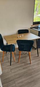 a wooden table and chairs in a room at Casuta CORE in Sadova +11 photos